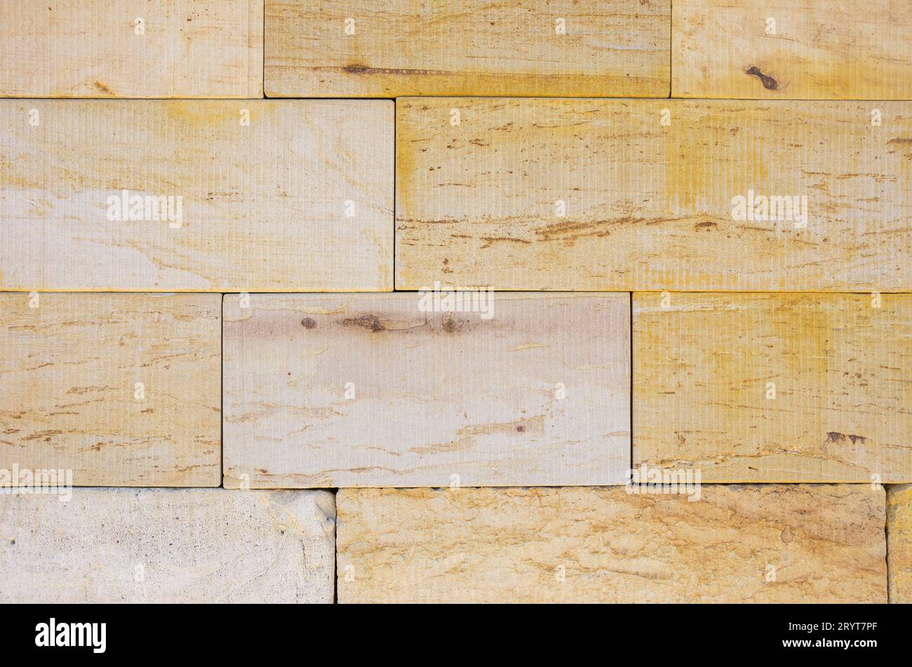Background and pattern of rectangular shaped slabs of yellow sandstone. Stock Photo
