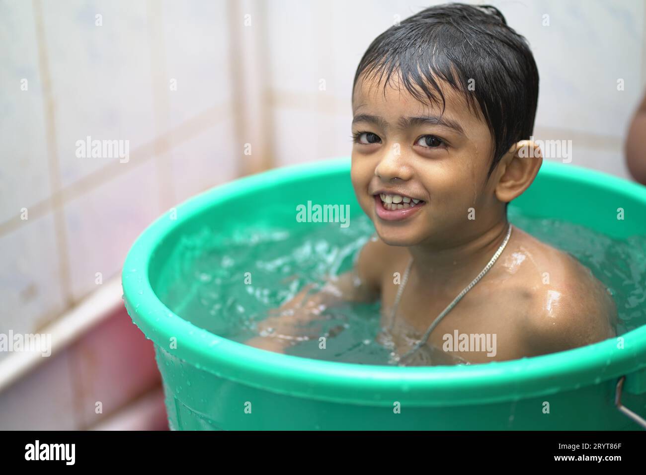 a-2-year-old-indian-baby-boy-enjoying-a-bath-in-a-green-tub-stock-photo-alamy