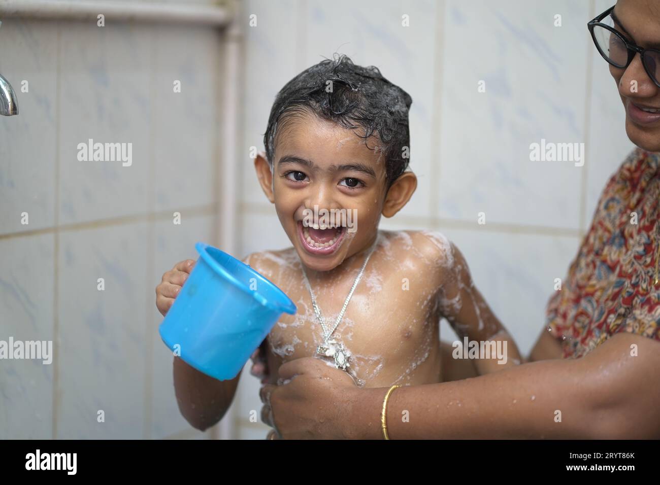 a-2-year-old-indian-baby-boy-enjoying-a-bath-in-a-green-tub-stock-photo