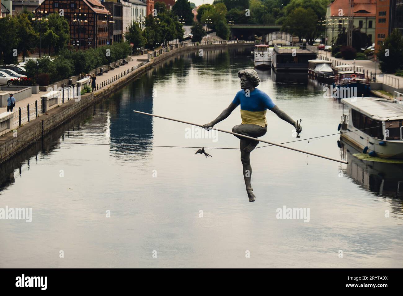 Bydgoszcz, Poland - August 2022 Brda river in Bydgoszcz Man crossing a river sculpture , of a man balancing on a wire, old grana Stock Photo