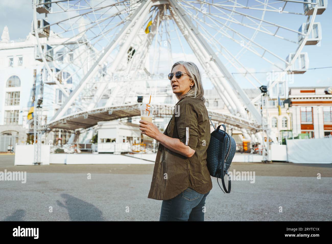 Silver-haired senior woman radiates joy and happiness as she embarks on delightful adventure on Ferris wheel. Retired old mature Stock Photo