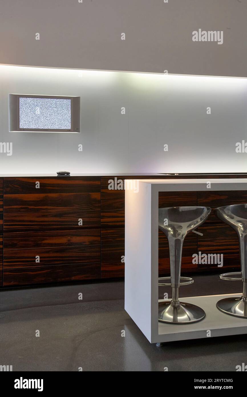 Galley kitchen detail in white with stools under island. End House