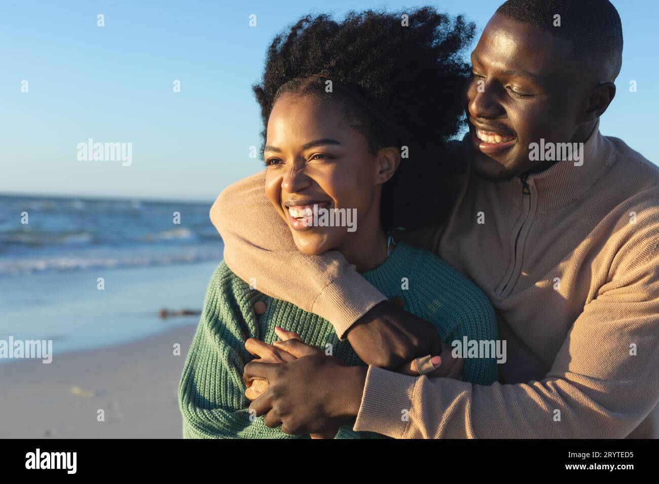 Happy african american couple embracing on sunny beach by the sea Stock ...