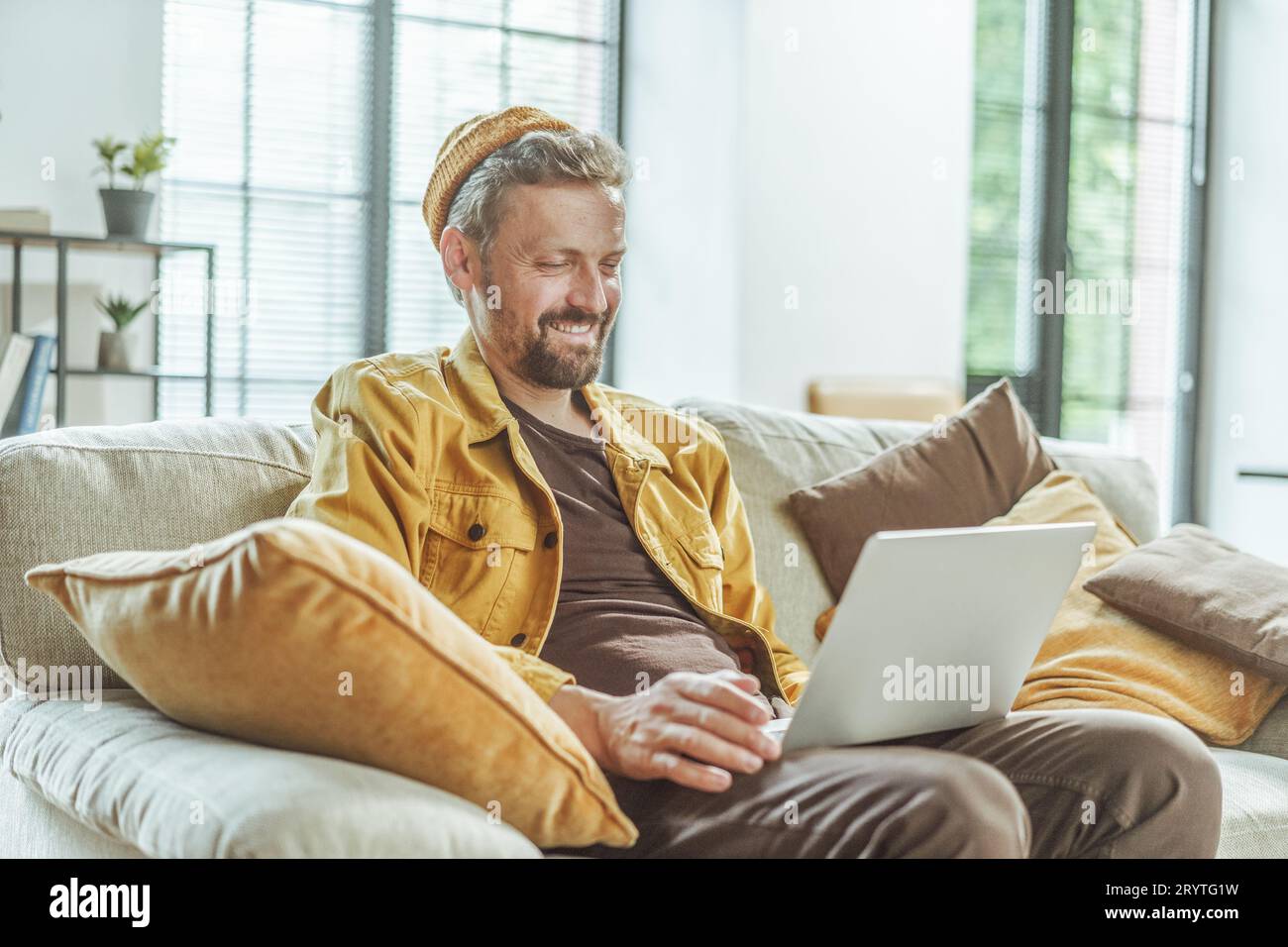Happy client watches the result of freelancer's work on computer. Man with focused attention, he views outcome of the freelancer Stock Photo
