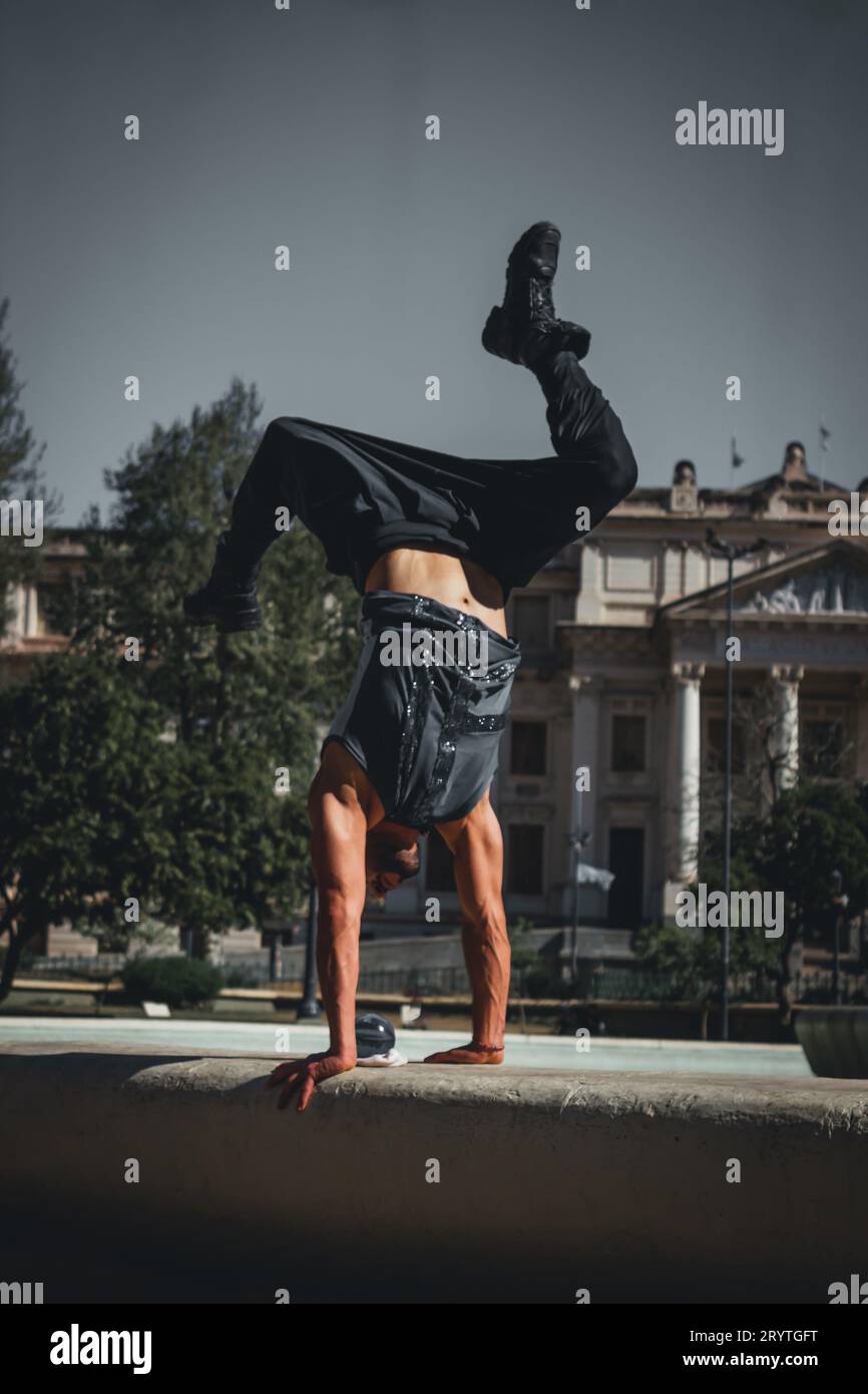 Handstand Outside A young adult male is performing a handstand in an outdoor setting, his ...