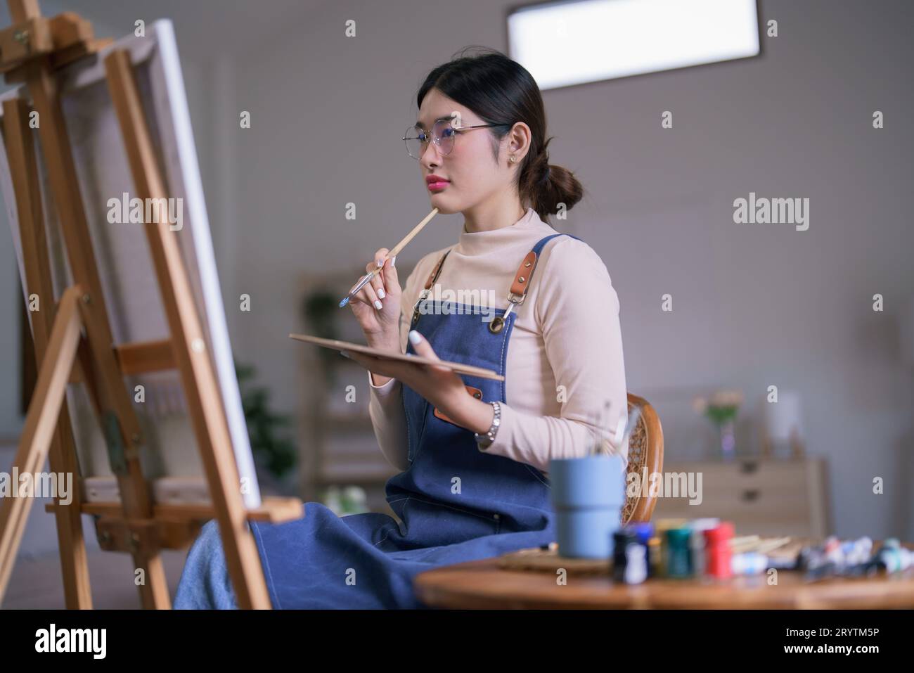 Thoughtful woman holding paint brush hi-res stock photography and ...