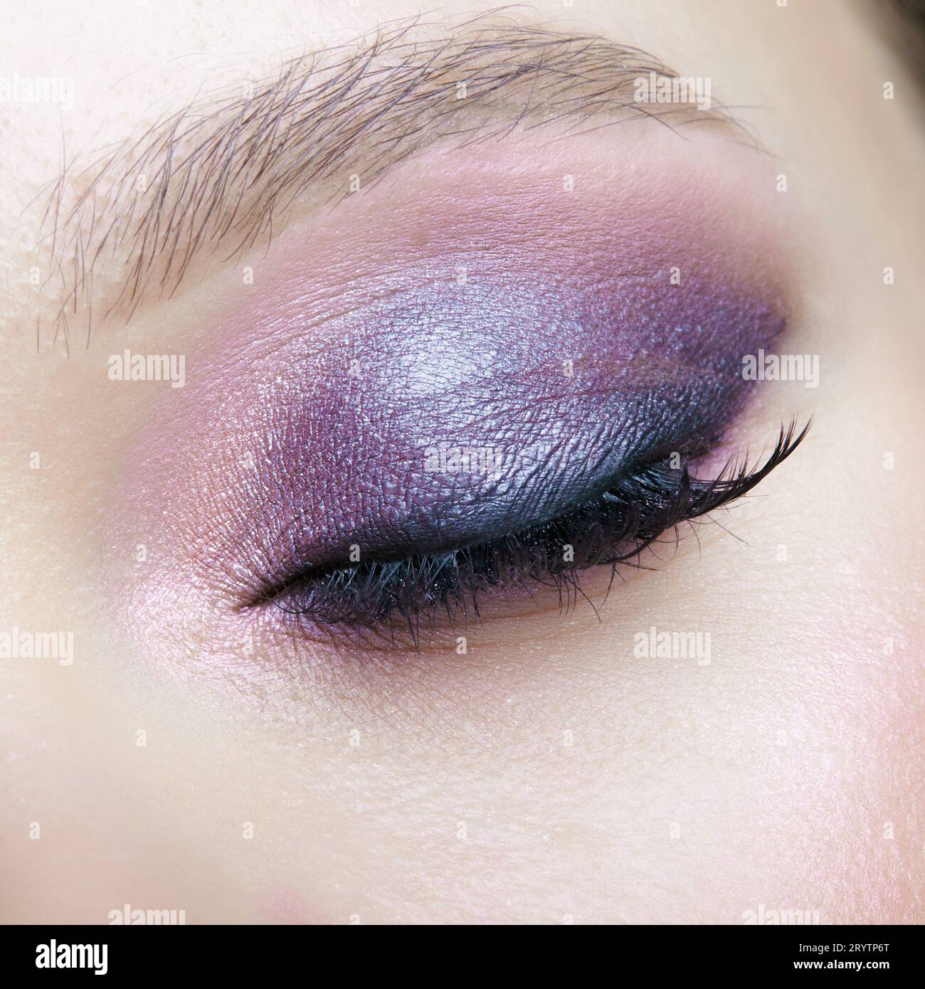 Closeup macro shot of human female eye. Woman with lilac beauty eyes makeup. Stock Photo