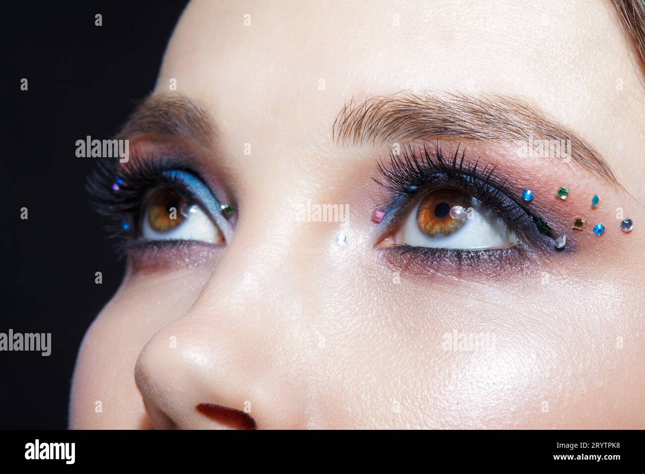 Closeup shot of human woman face. Female with face and eyes beauty makeup with blue eye shadow make up and rhinestones Stock Photo