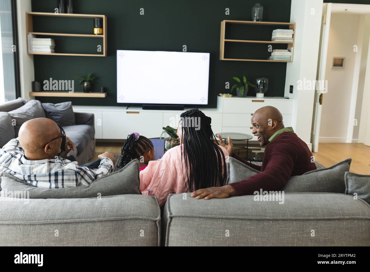 African american parents, son, daughter and grandfather watching tv with copy space, slow motion Stock Photo