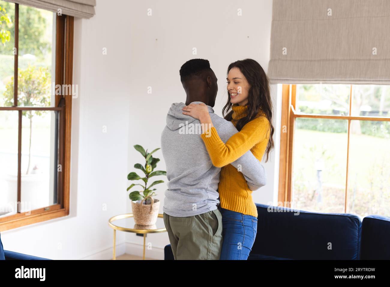 Happy diverse couple dancing in living room at home Stock Photo