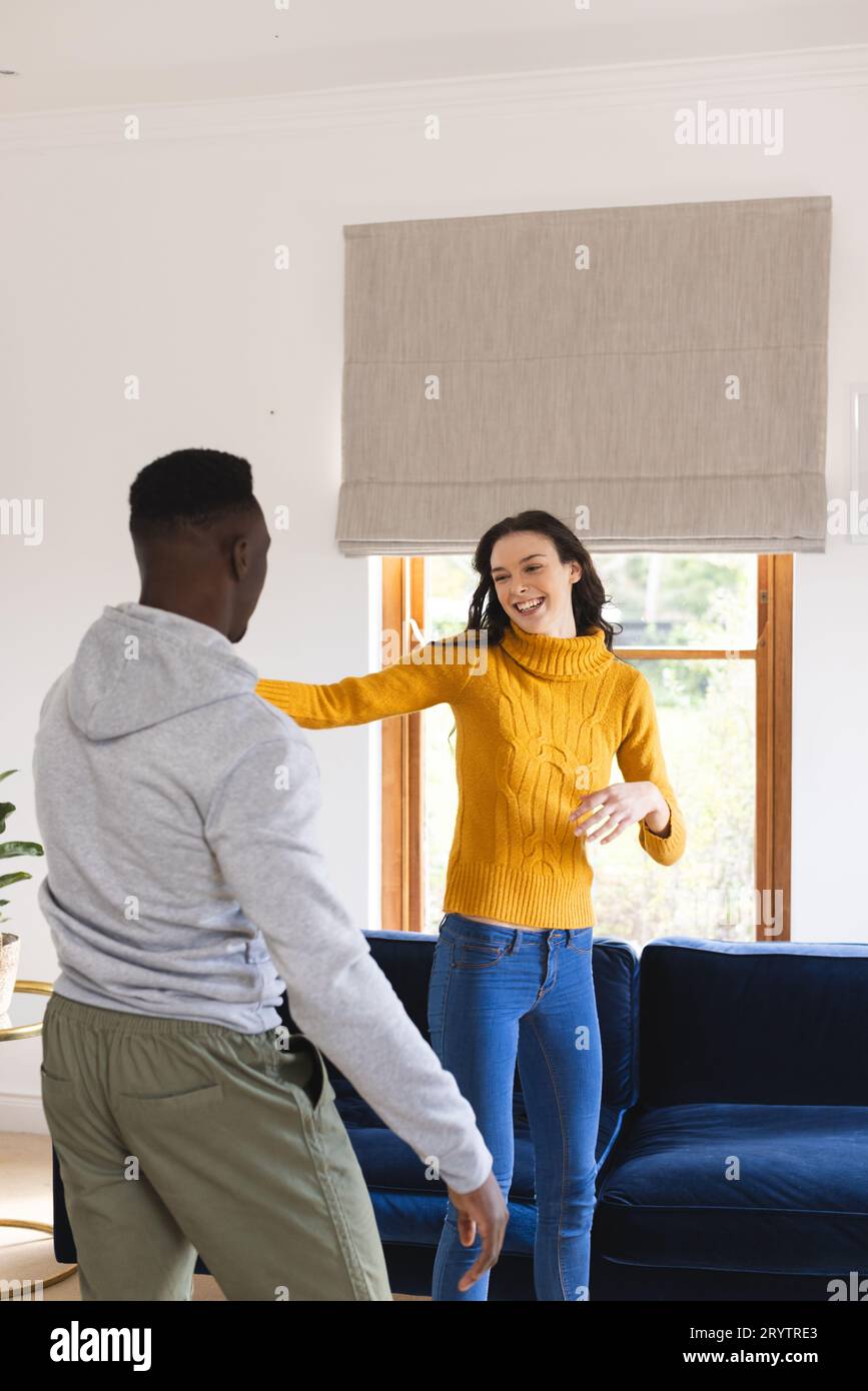 Happy diverse couple dancing in living room at home Stock Photo