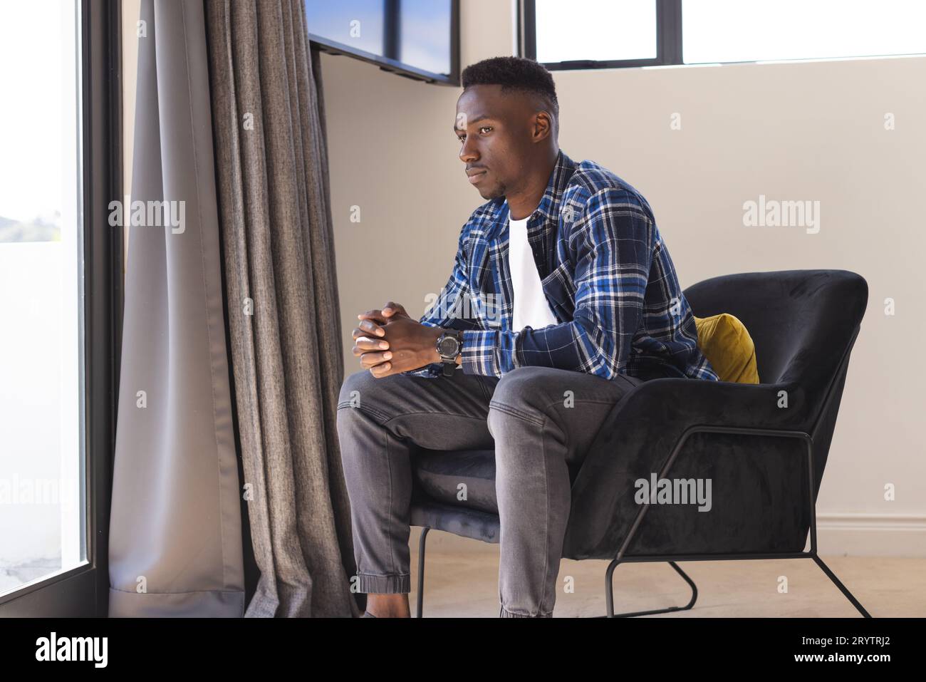 Sad young man sitting home hi-res stock photography and images - Alamy