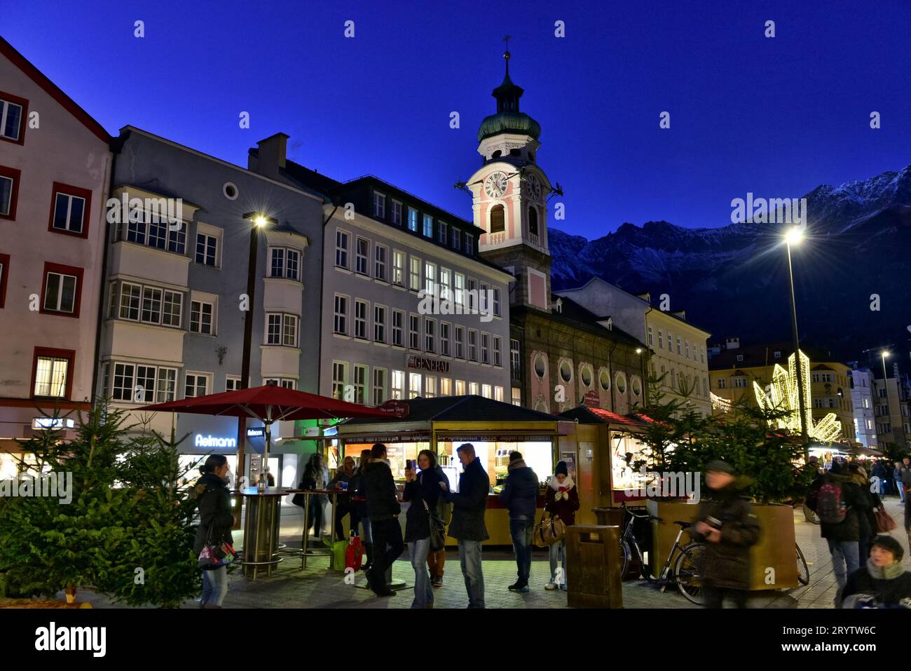 Belltower of the Hospital Church of the Holy Spirit towering over the Christmas market on Maria Theresien Straße, Innsbruck, Austria Stock Photo