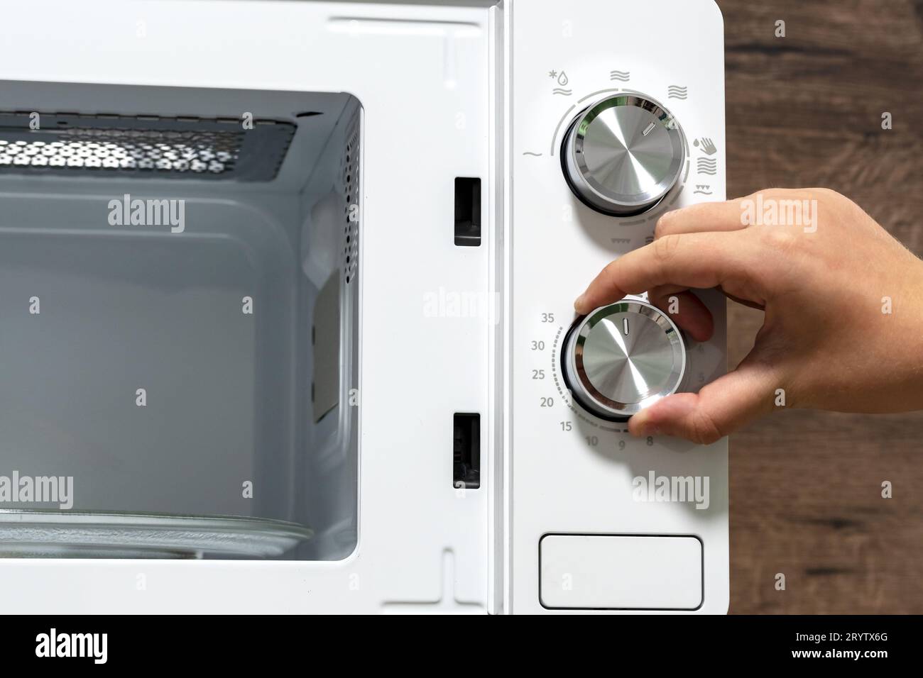 hand using an oven. Girl Adjusting Temperature Of Microwave Oven.Using
