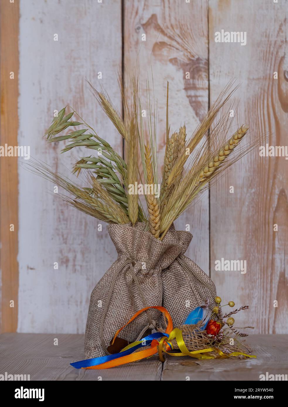 ears of grain sticking out of a linen bag, a symbol of fertility and abundant harvests, an element of naturalness and simplicity. The boards give the Stock Photo