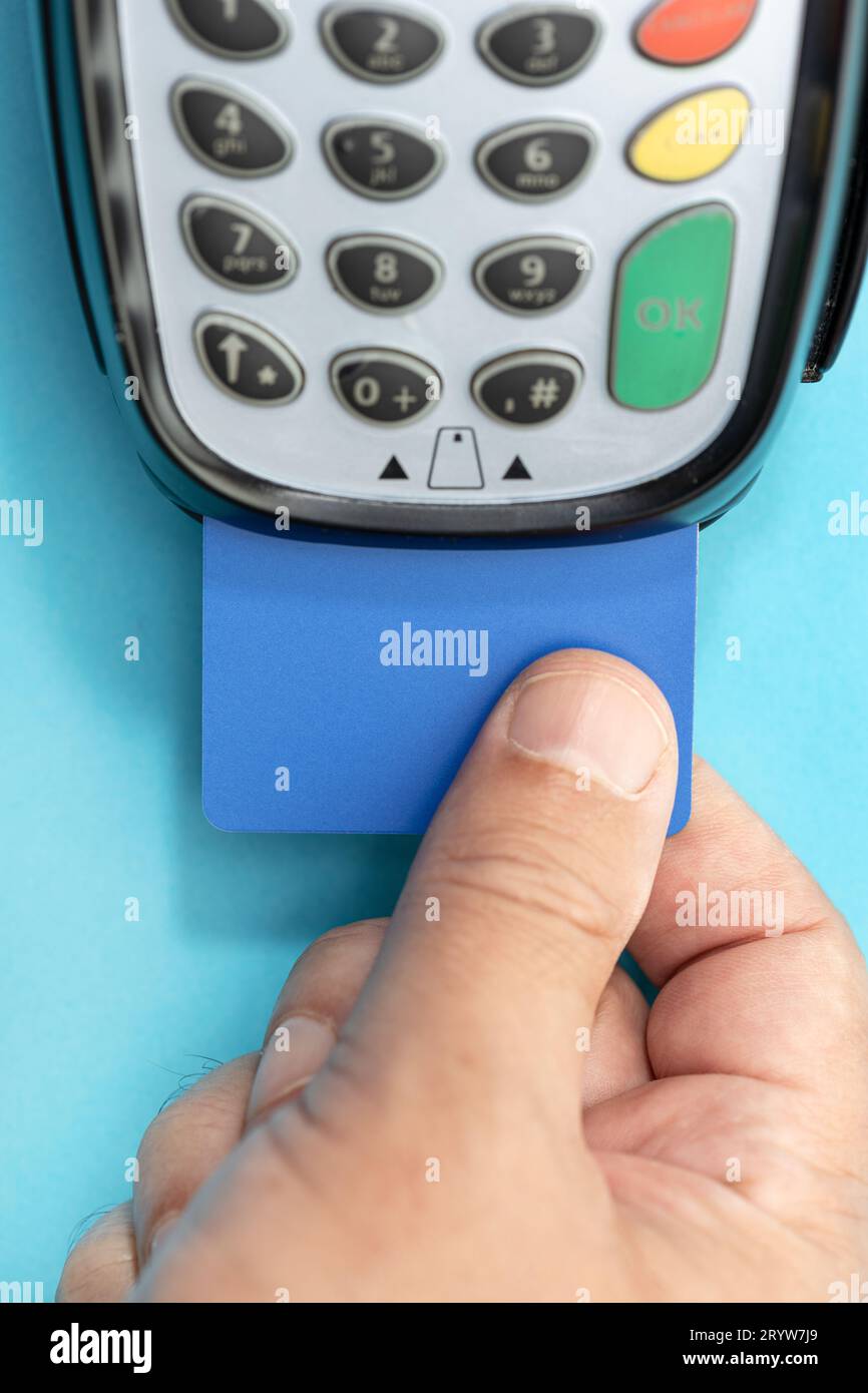 Hand put Credit card into payment terminal on blue background Stock ...
