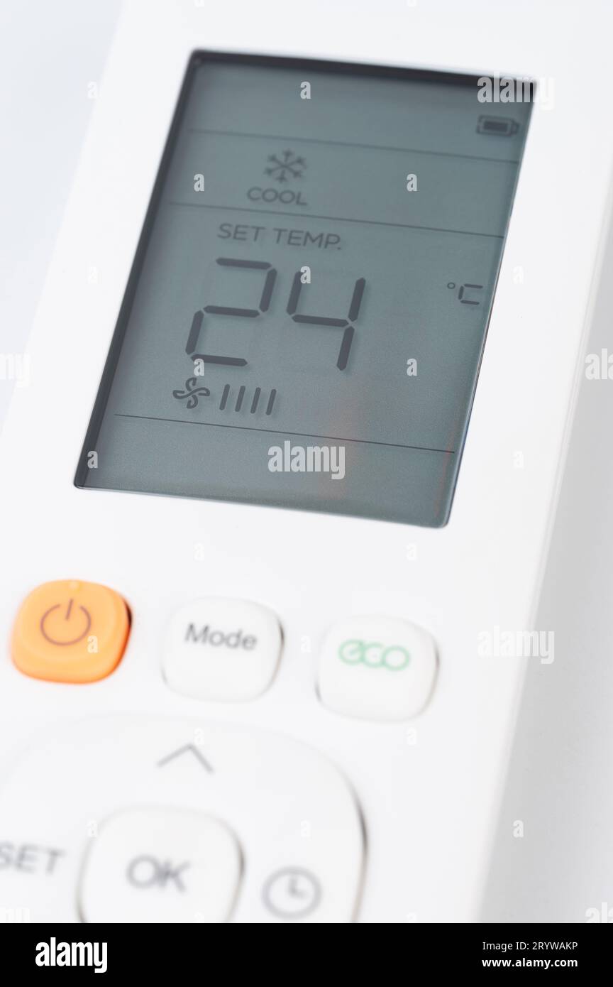 Set temperature on air conditioner with remote control buttons Stock