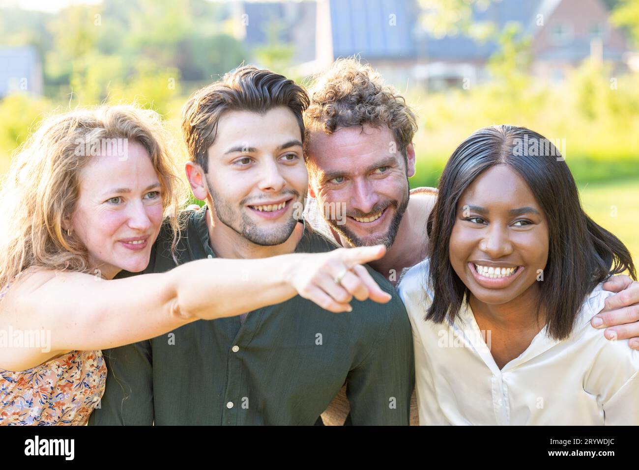 Group of diverse multi ethnic young friends or colleagues enjoying each others company a in a casual outdoor setting after work Stock Photo
