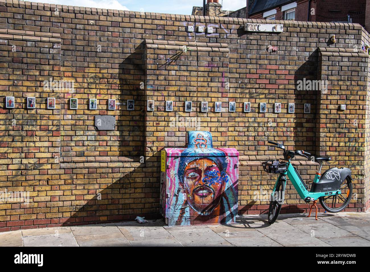 A Tier Hire bike against a wall and street art in Brick Lane, London, E1. Stock Photo