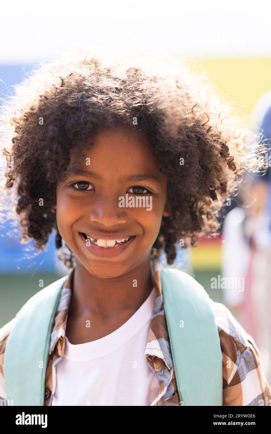 Vertical portrait of smiling african american elementary schoolboy in ...