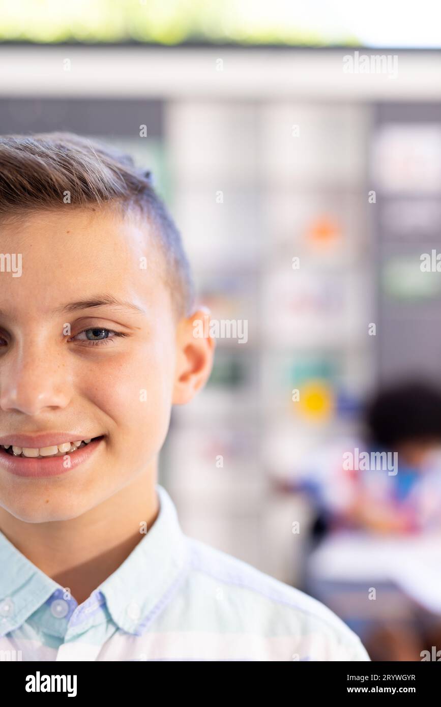 Half face portrait of happy, smiling caucasian schoolboy in classroom, with copy space Stock Photo