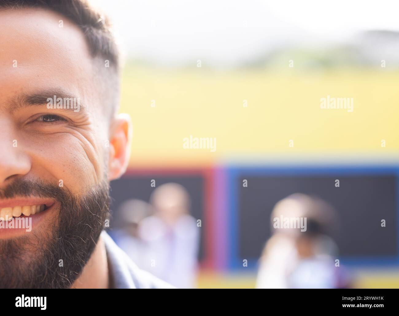 Half face portrait of smiling, bearded caucasian male school teacher outdoors, with copy space Stock Photo