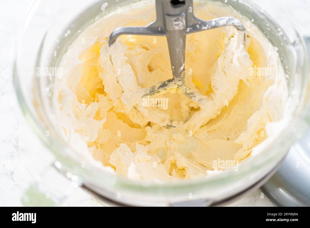 Mixing ingredients in kitchen electric mixer to make lemon buttercream