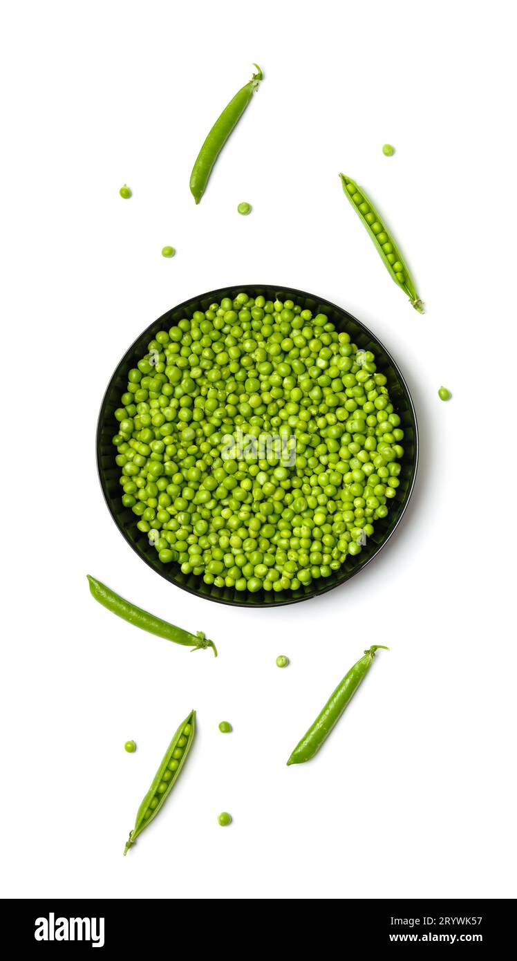 Peeled grains of fresh green peas in a round black plate and green pea pods on a white background, top view. Vegetable protein, healthy products. Stock Photo