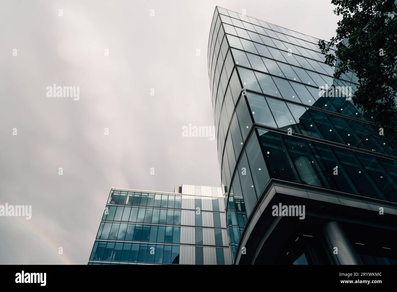 London, UK - August 26, 2023: Office building in the Queens Walk by the City Hall. Low angle view of the glass facade against cloudy sky Stock Photo