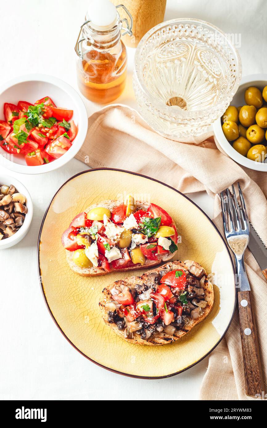 Delicious bruschettas with mushrooms, blue cheese, olives and tomatoes Stock Photo