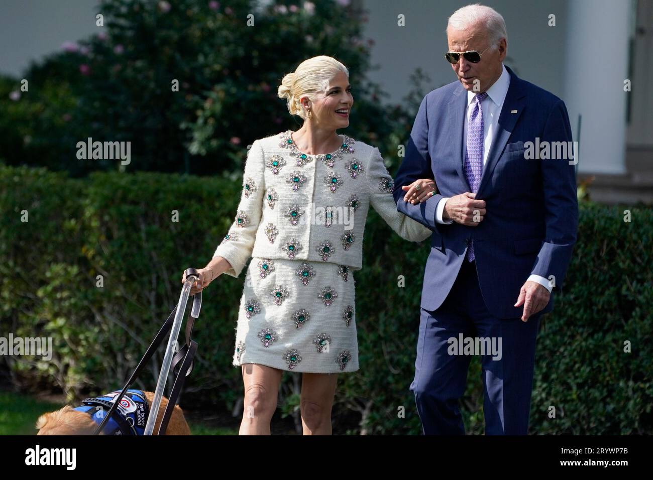 President Joe Biden walks with actress Selma Blair and Blair's service