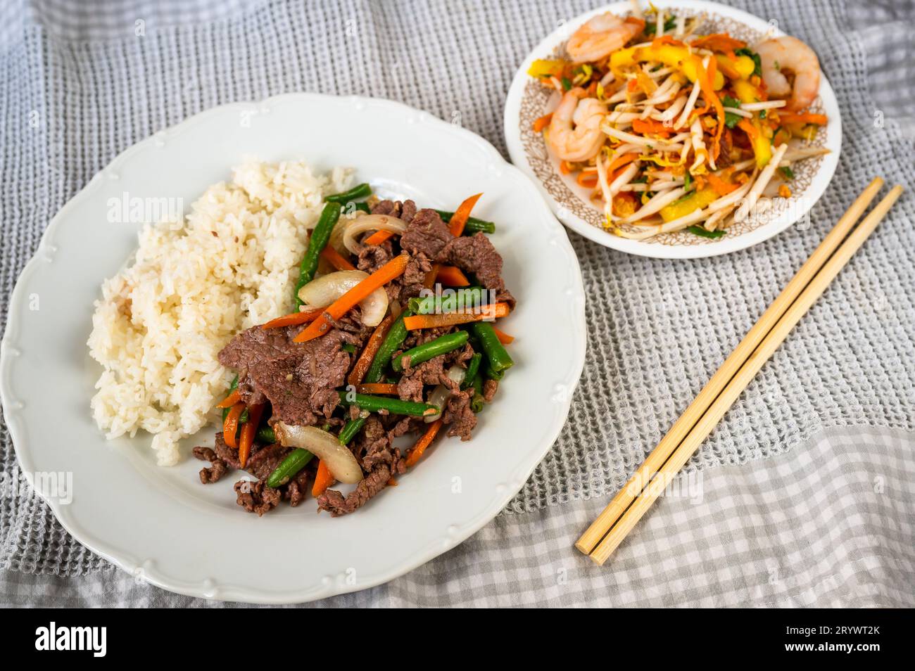 Sliced beef with green beans and rice, mango salad with shrimp, chopstick. Vietnamese meal. Stock Photo