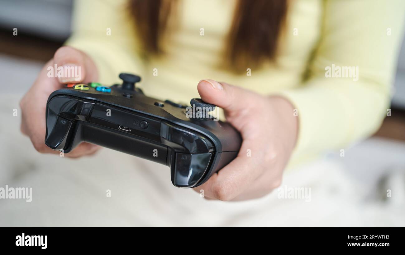 Young Asian woman gamer controller video console playingÂ holding hobby playful Online Video Game enjoyment eSport Cyber Games I Stock Photo