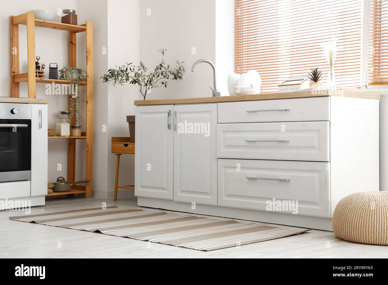 Interior of light kitchen with white counters and striped carpet Stock ...