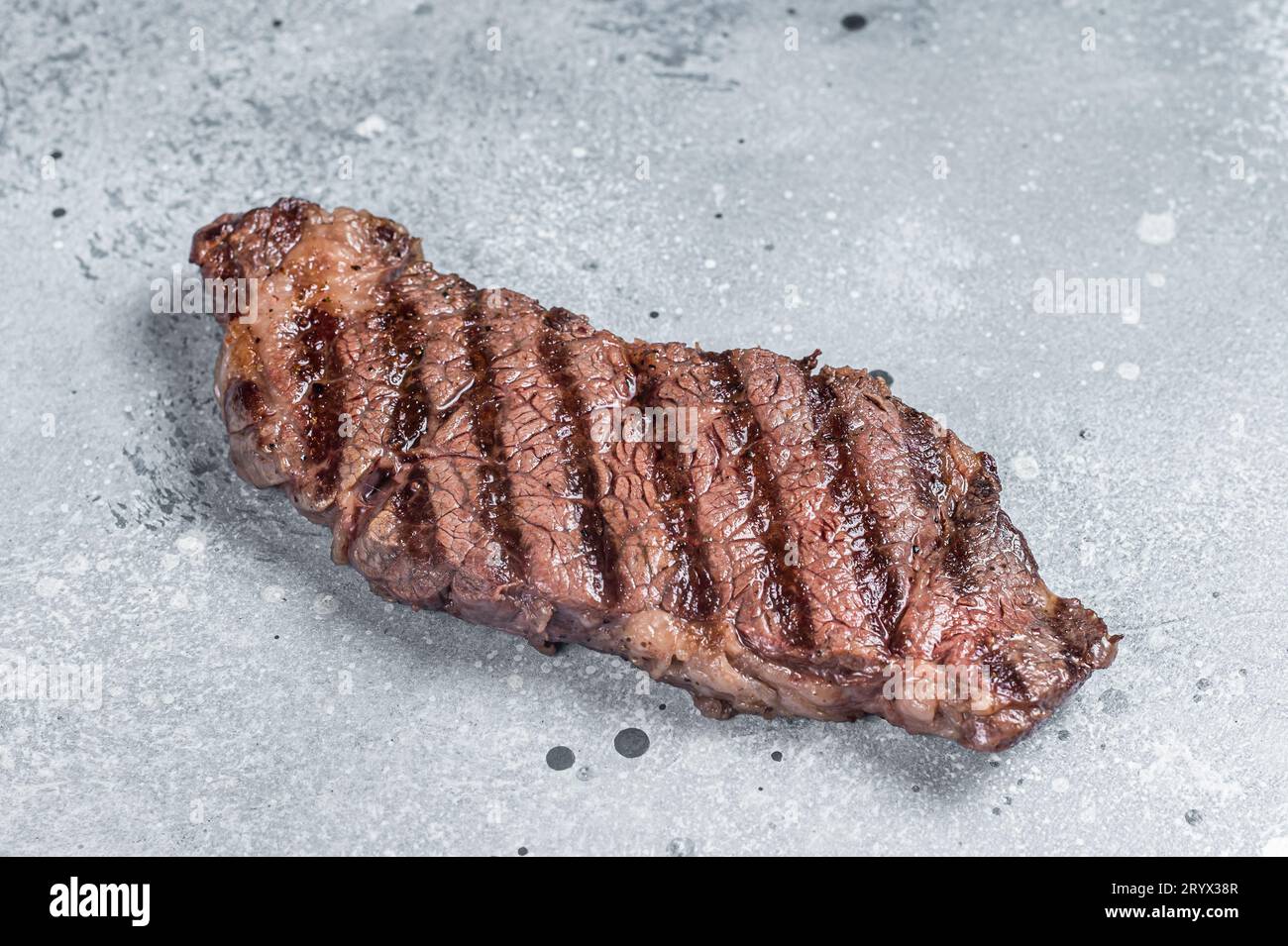 BBQ Grilled denver beef meat steak on a table. Gray background. Top view. Stock Photo