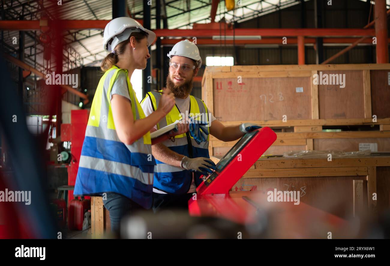 Both of mechanical engineers are checking the working condition of the new machine after