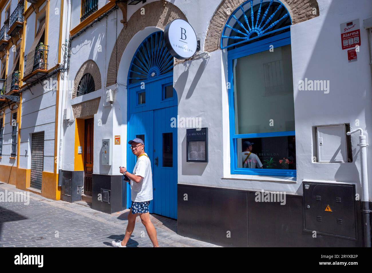 Seville, Spain, Chinese Tourist Walking in Front of Exterior Contemporary Spanish Bistro Restaurant, 'La Brunilda', Street Scene Stock Photo