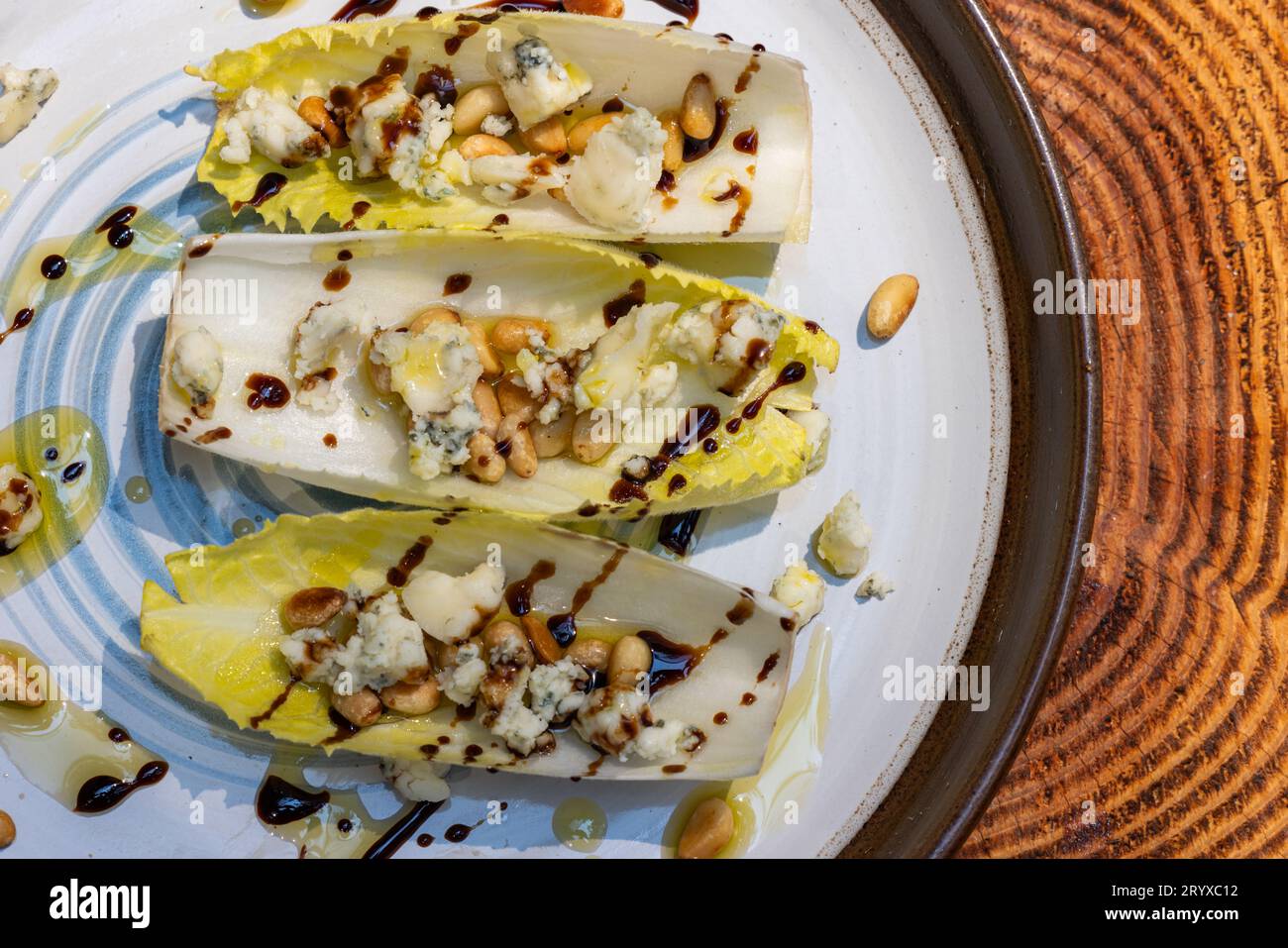 Vegetarians appetizer made with fresh Belgium endive boats stuffed with toasted pine nuts, bleu cheese and fresh olive oil topped with a balsamic driz Stock Photo