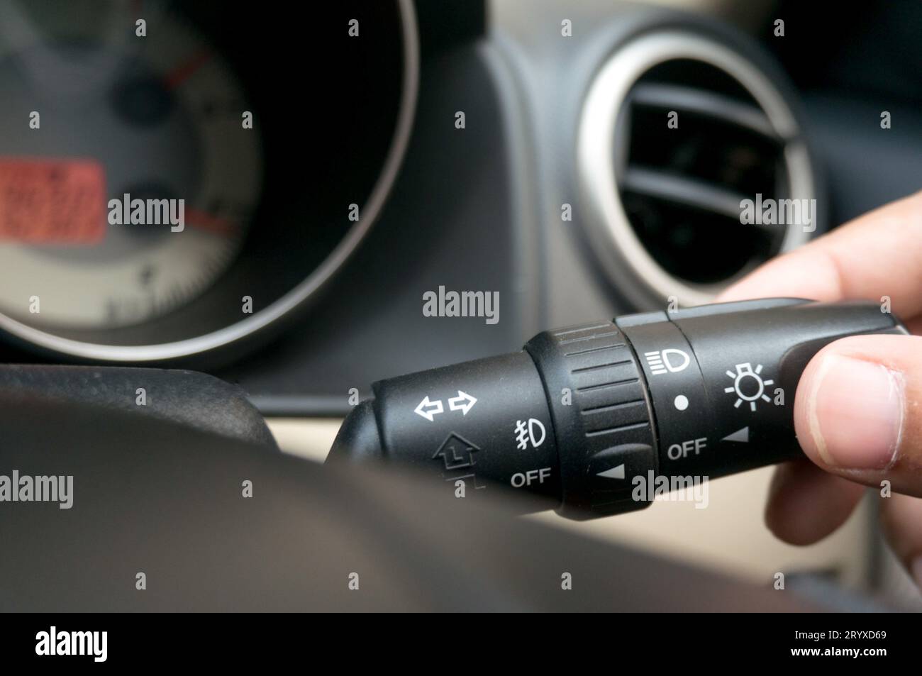Man driving hands pushing turn on light switch on steering wheel in the