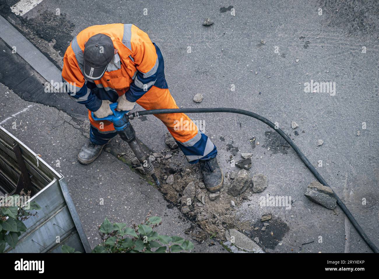 A utility employee during the replacement of a curb stone Stock Photo