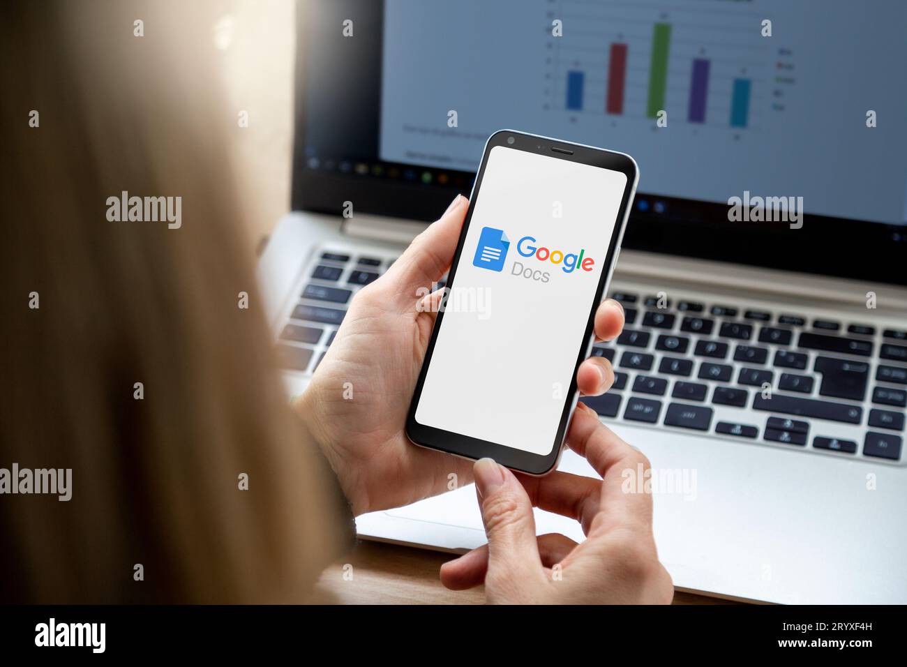 Smartphone with Google Docs application on screen. Close up view of mobile phone holding by a woman. Stock Photo
