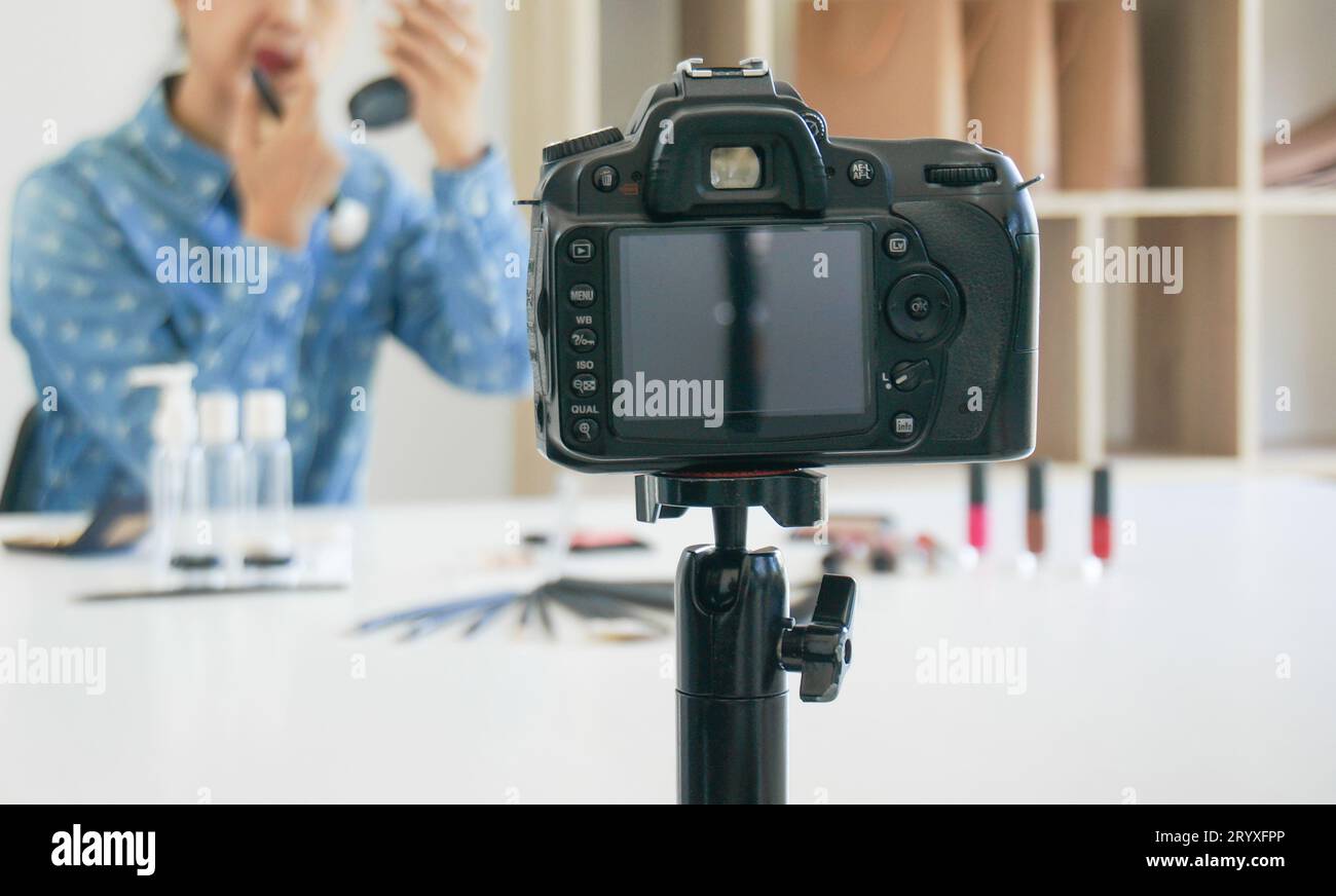 Professional Woman blogger vlogger is showing cosmetics products with recording videoÂ  makeup artist applies blush powder and w Stock Photo