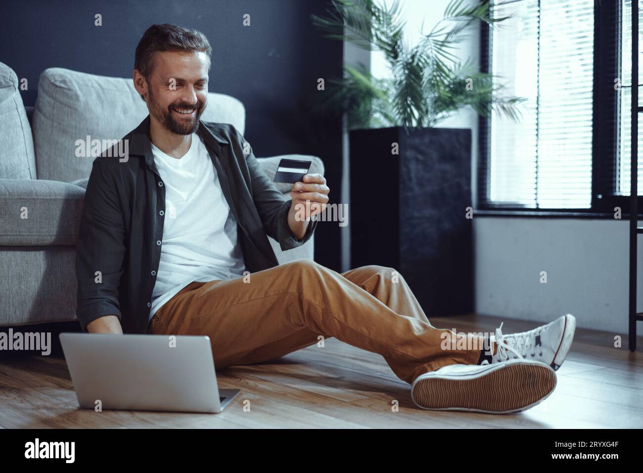 happy-customer-is-depicted-sitting-on-floor-at-home-with-laptop