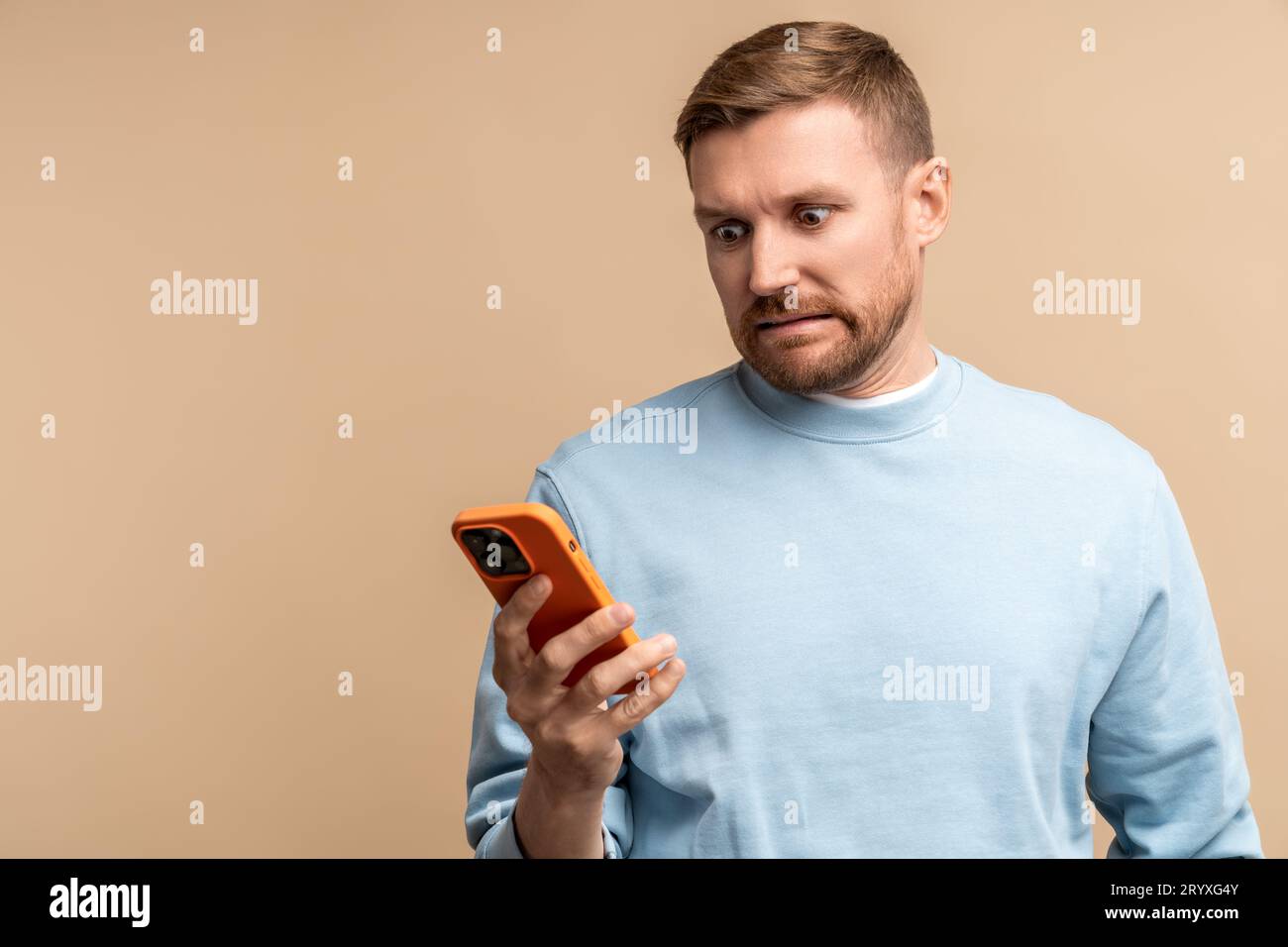 Scared frustrated man reding message in smartphone looking at screen on ...