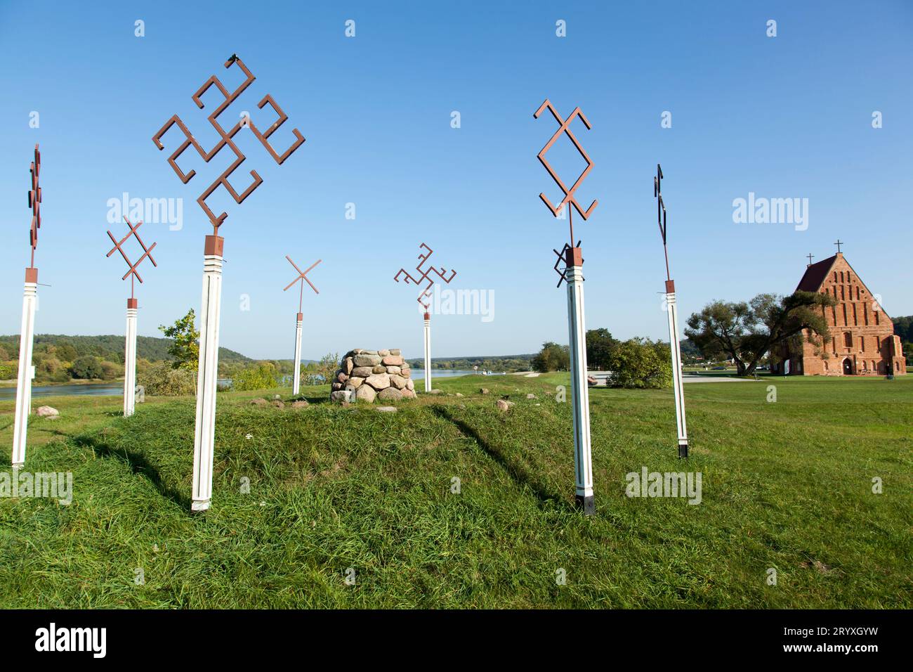 The view of modern Pagan altar by Neman River and the historic 16th century church in a background in small Zapyskis town (Lithuania). Stock Photo