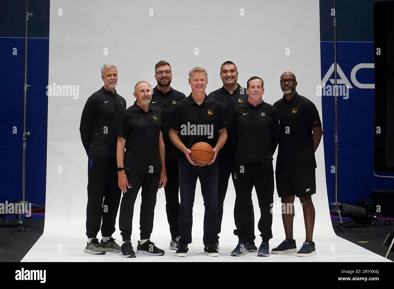 Golden State Warriors head coach Steve Kerr, center, poses for photos with assistants Bruce