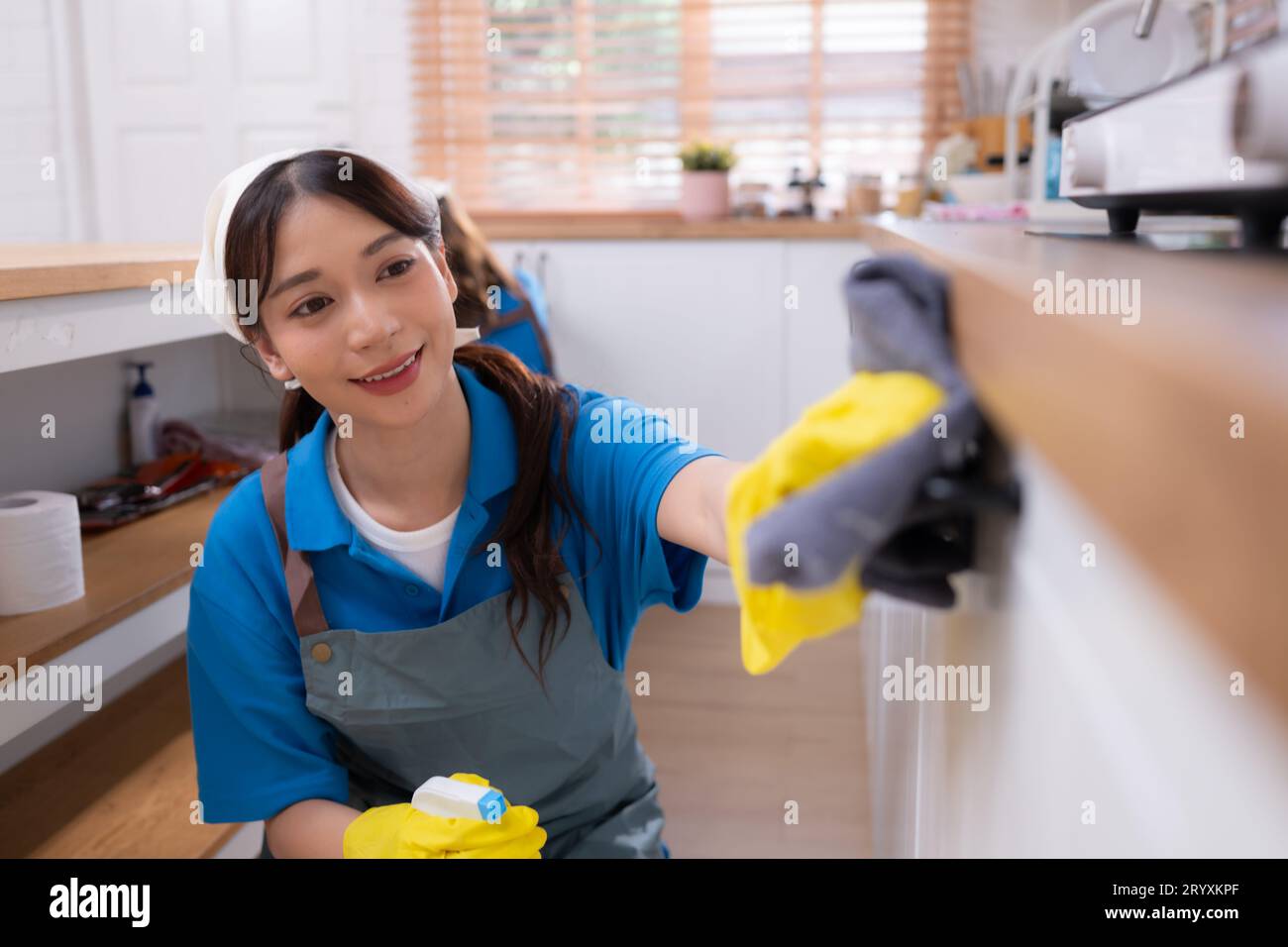 Asian young woman cleaning the countertops cupboard in the kitchen. housework concept Stock Photo