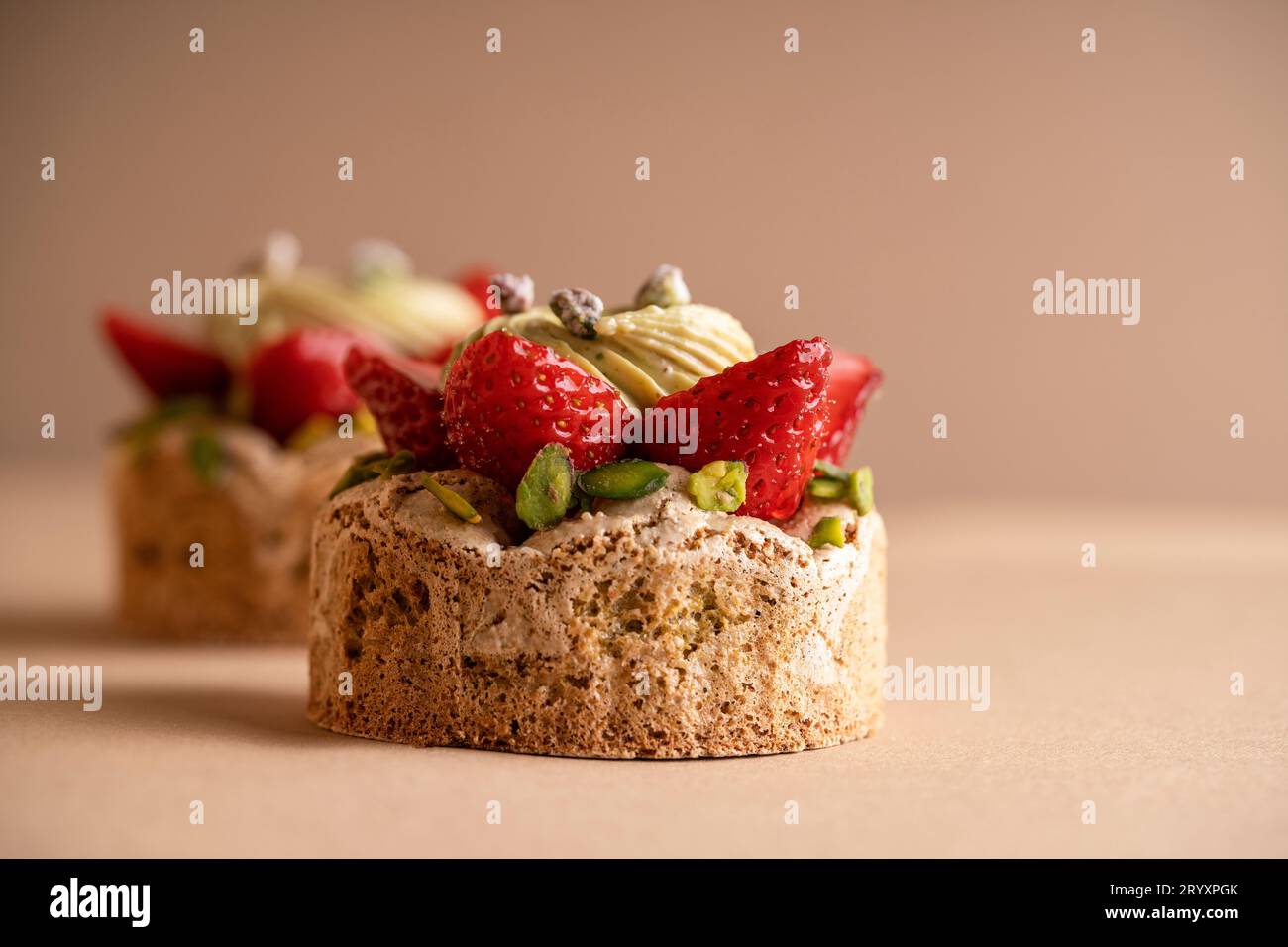 A delicious dessert composed of two decadent strawberry and pistachio cakes Stock Photo