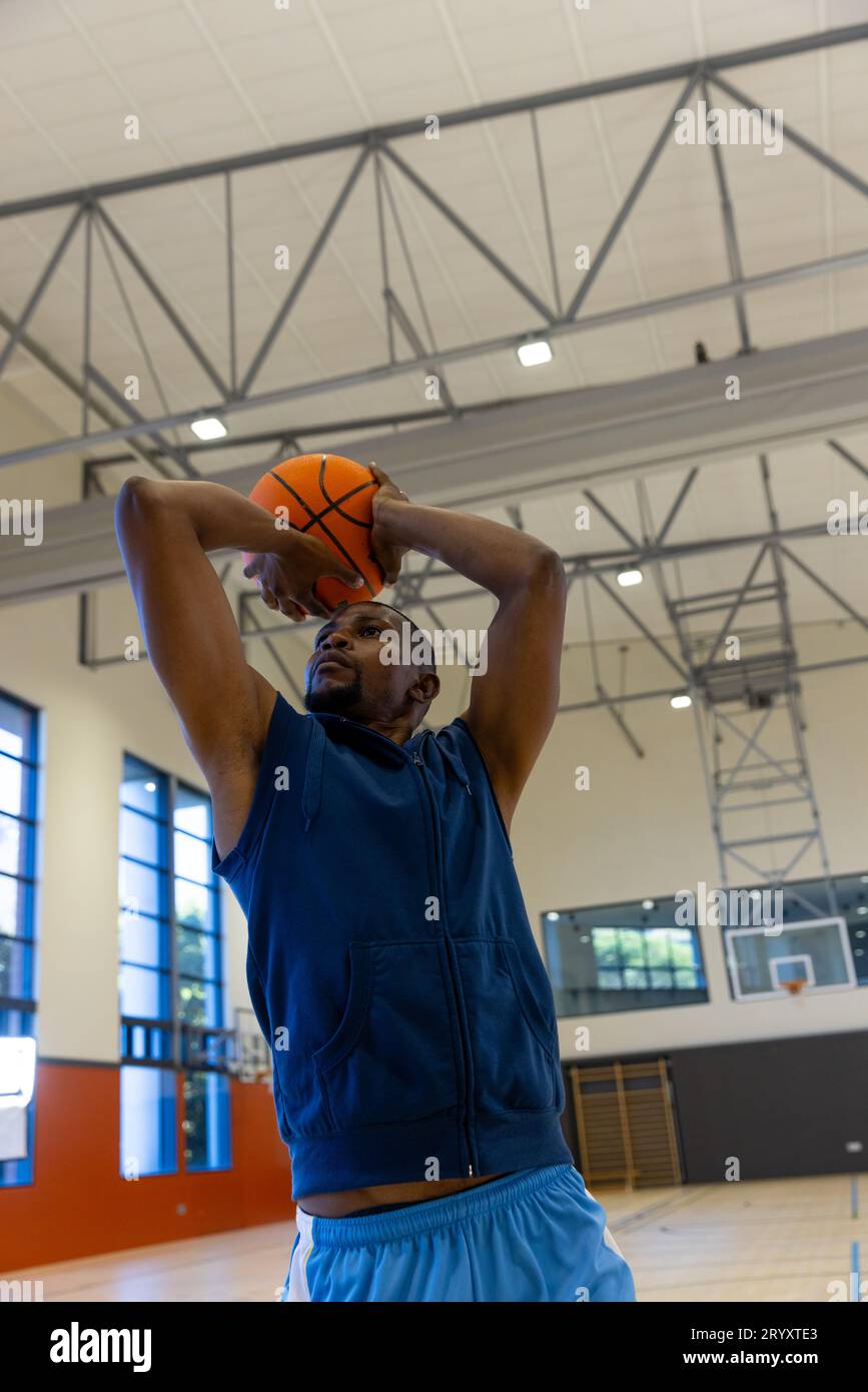 Biracial male basketball players wearing blue sports clothes and shooting  basketball at gym. Sport, activity and lifestyle, unaltered, copy space  Stock Photo - Alamy