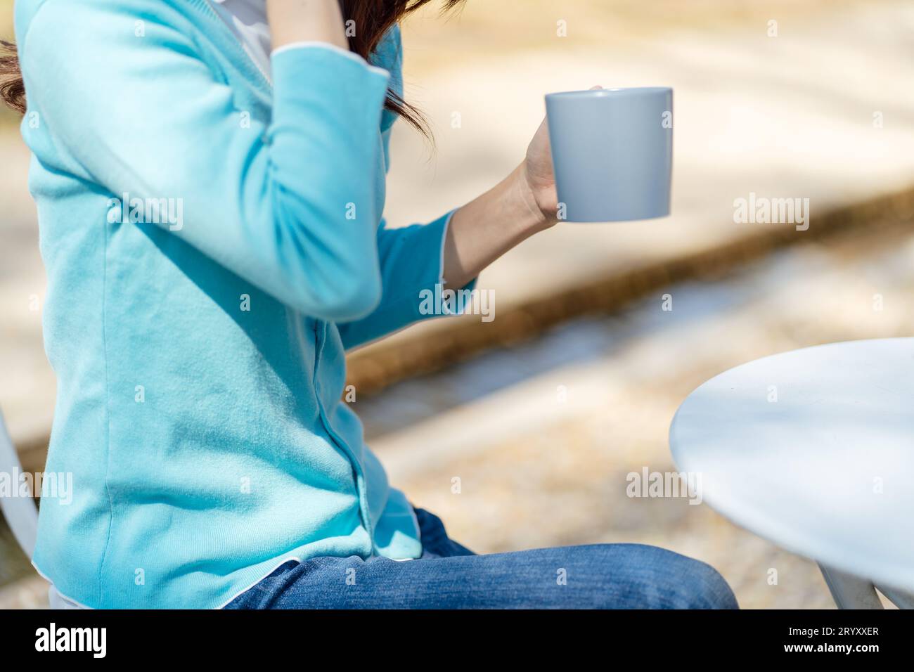 Woman hands holding cup of coffee in the park Stock Photo
